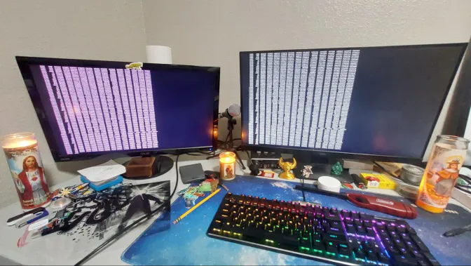 two monitors running the IOzone benchmarks, flanked by lit prayer candles